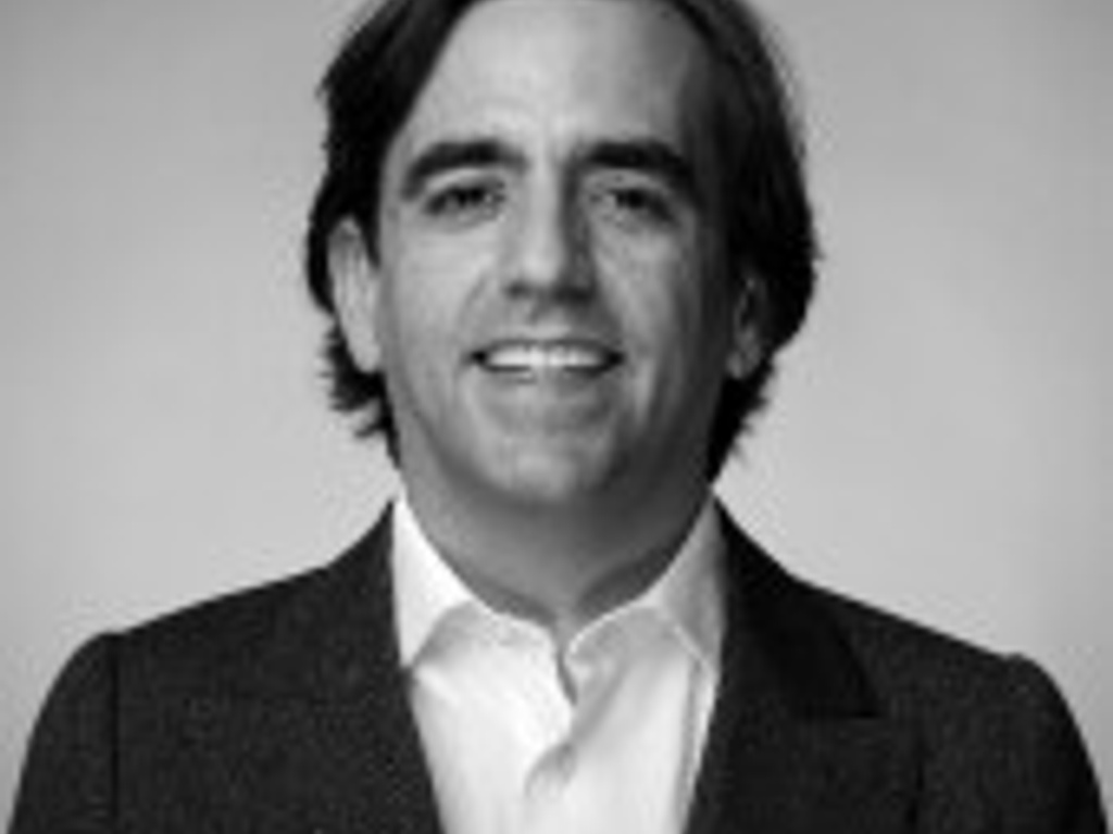 Black and white portrait of a smiling man wearing a suit and tie.