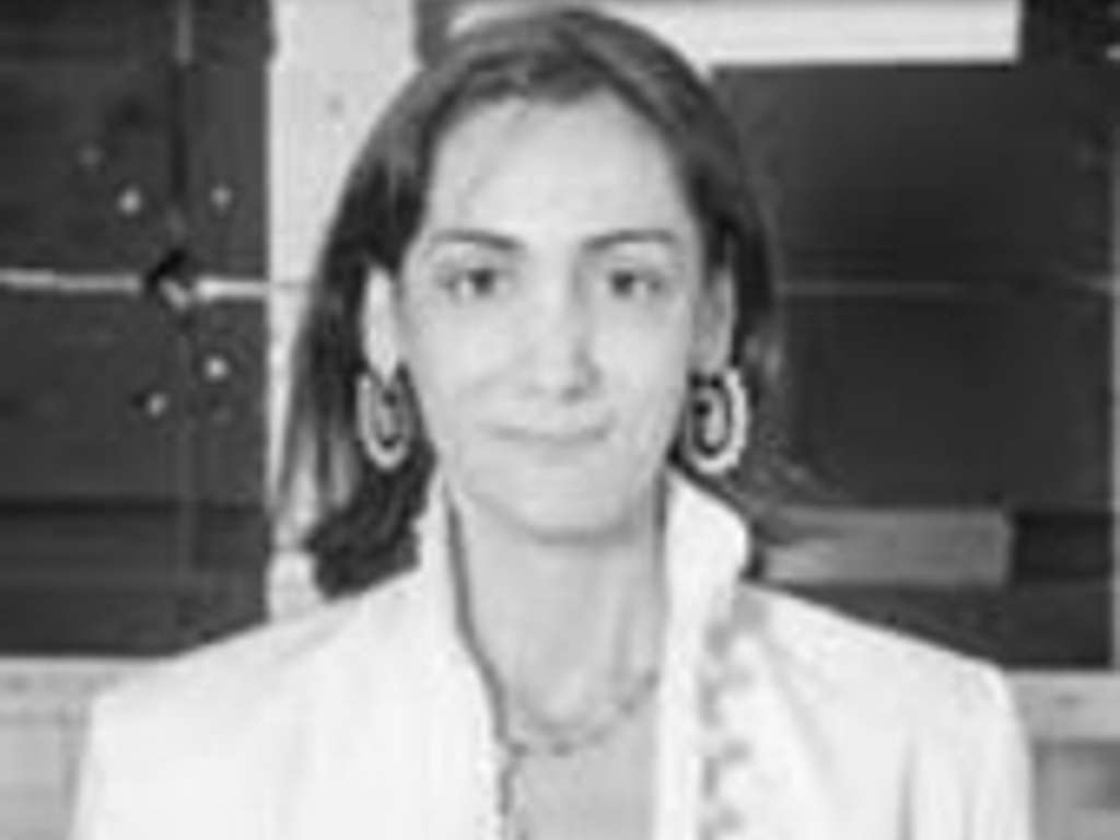 Black and white portrait of a woman wearing earrings and a white blouse.