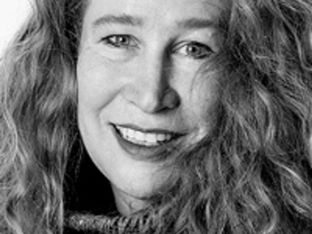 Black and white portrait of a smiling woman with curly hair.