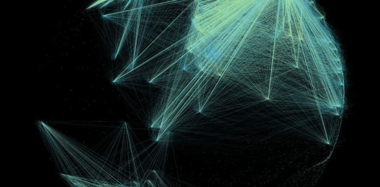 A colorful night view of Amsterdam with illuminated buildings reflected in the calm water of a canal.