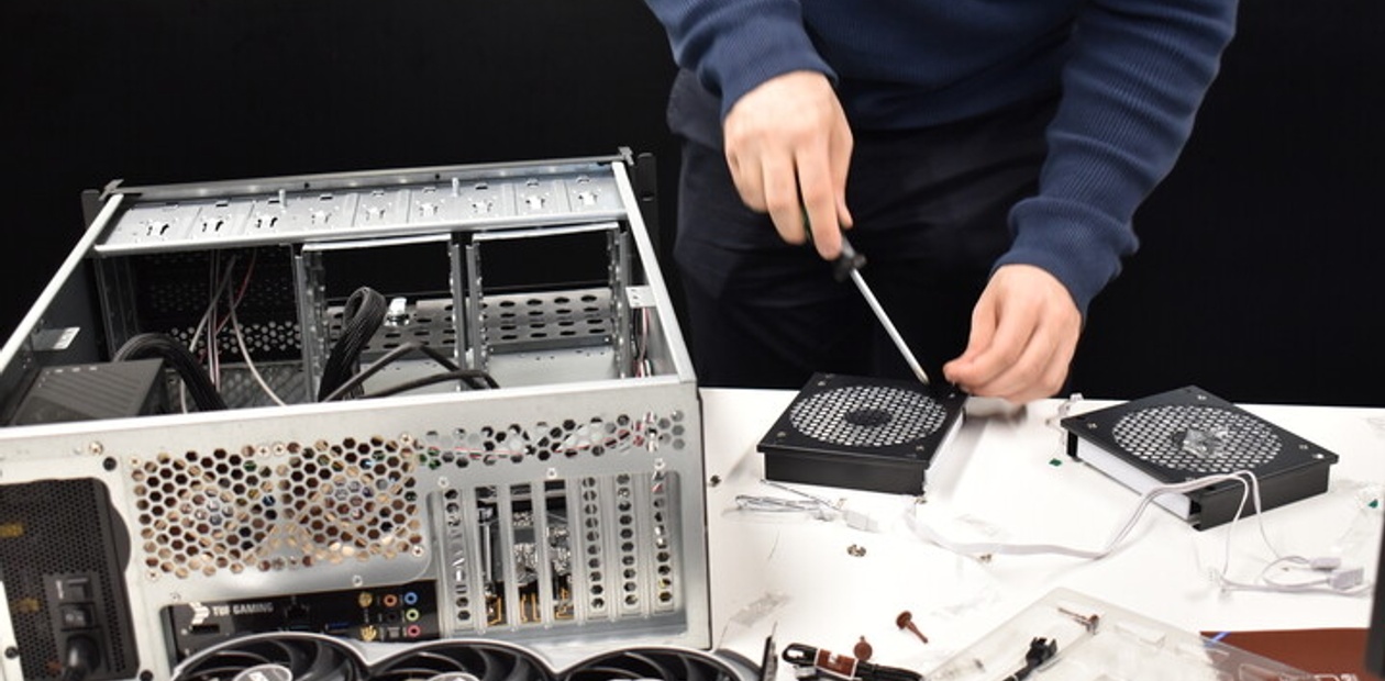 A person is assembling a computer by installing components into a PC case.