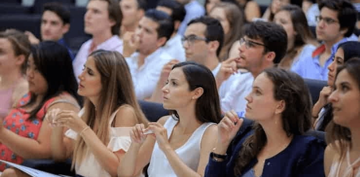 A group of students sitting in an auditorium, attentively listening to a presentation.