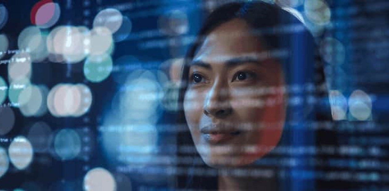 A close-up portrait of a woman with digital data overlay and blurred lights reflecting on her face.