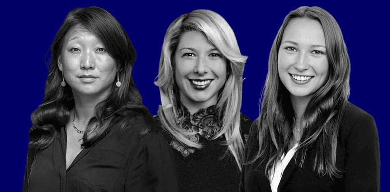 Three women with different hairstyles smiling against a blue background.