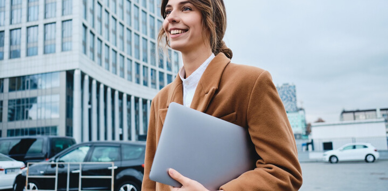 Master in management & strategy: woman with a coat and a computer