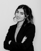 Black and white portrait of a smiling woman in a business suit.