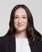 Portrait of a smiling woman wearing a black blazer and white top.