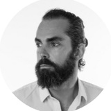Black and white portrait of a man with a full beard and mustache, looking to the side.