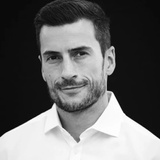 Black and white portrait of a smiling man in a white shirt