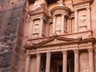 Ancient facade of the Al-Khazneh temple carved from a sandstone rock face in Petra, Jordan.