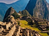 Aerial view of Machu Picchu, an ancient Incan city set high in the Andes Mountains in Peru, with lush greenery and a dramatic mountain backdrop.