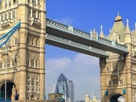 Tower Bridge in London with a passing boat on a sunny day.