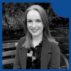 A portrait of a smiling woman with a blue circular overlay on a black and white photo.