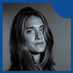 Black and white portrait of a woman with long hair looking directly at the camera.