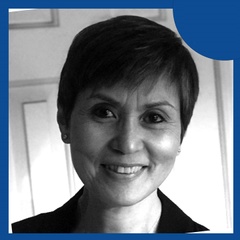 Portrait of a smiling woman with short hair in a monochrome setting with a blue circular design on the top right corner.