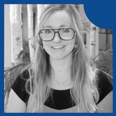 A smiling woman with glasses, wearing a black top, framed by a blue circular border against a black and white background.
