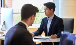 Two businessmen having a discussion in a modern office setting.