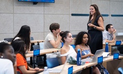 A classroom scene with students engaged in a lesson led by a teacher.
