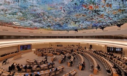 A grand assembly hall filled with delegates and a beautifully painted ceiling.