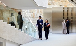 A group of professionals engaging in conversation in a modern architectural space.