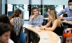 A group of people engaged in discussion in a classroom setting.