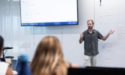 A teacher presenting a lesson in front of a classroom.