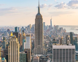 A panoramic view of a bustling city skyline featuring the Empire State Building.