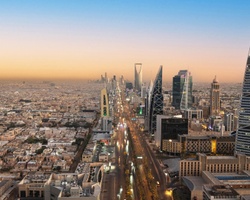 A panoramic view of Riyadh's skyline at sunset featuring modern skyscrapers.