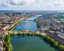 A panoramic view of a vibrant city landscape with rivers and greenery.