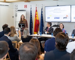 A business presentation is taking place with speakers and an audience.