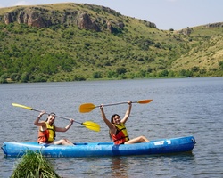 Two people joyfully kayaking on a lake.