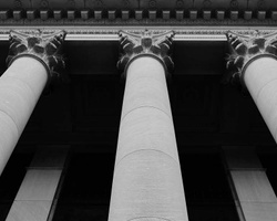 Black and white image showing the detailed view of classical architectural columns on a building facade.