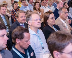 A diverse group of people seated in an audience during a conference or event.