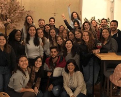 A group of happy people posing for a photo in a cozy indoor setting, likely a casual social gathering or celebration.