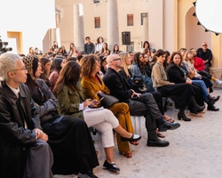 A diverse group of people sitting together at an outdoor event.
