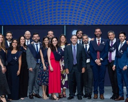 A graduation ceremony group photo with students and faculty members at a university.