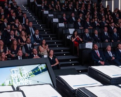 A large audience gathered in a modern auditorium for an event.