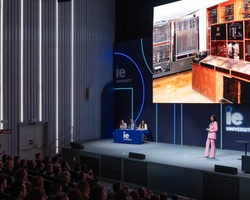 A presentation at a university featuring a historic computing machine displayed on a large screen.
