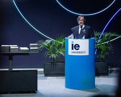 A speaker presents at an event held by IE University.