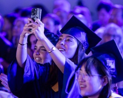 A group of graduates celebrating during a ceremony with joyful expressions.
