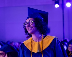 A graduate smiles during a commencement ceremony.