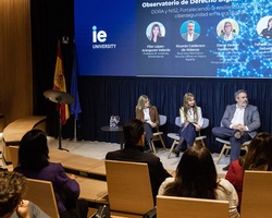 A panel discussion taking place at IE University with an audience in attendance.