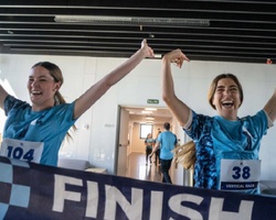 Two athletes celebrate joyfully after crossing the finish line in a competition.
