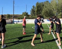 A group of people practicing boxing on a grassy field.