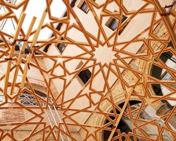 A complex geometric ceiling structure made of interlocking wooden beams.