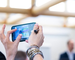 A person taking a photo with a smartphone at an event.
