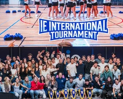 A large group of people celebrating at the IE International Tournament event.