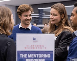 Group of young professionals engaging in conversation at a mentoring program event.
