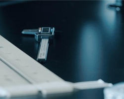 A close-up of a caliper and measuring tools on a black table.
