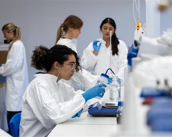 A group of women in lab coats working in a laboratory setting.